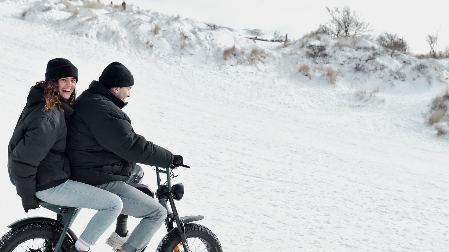 A man and a woman are riding a Super73 ebike in the snow