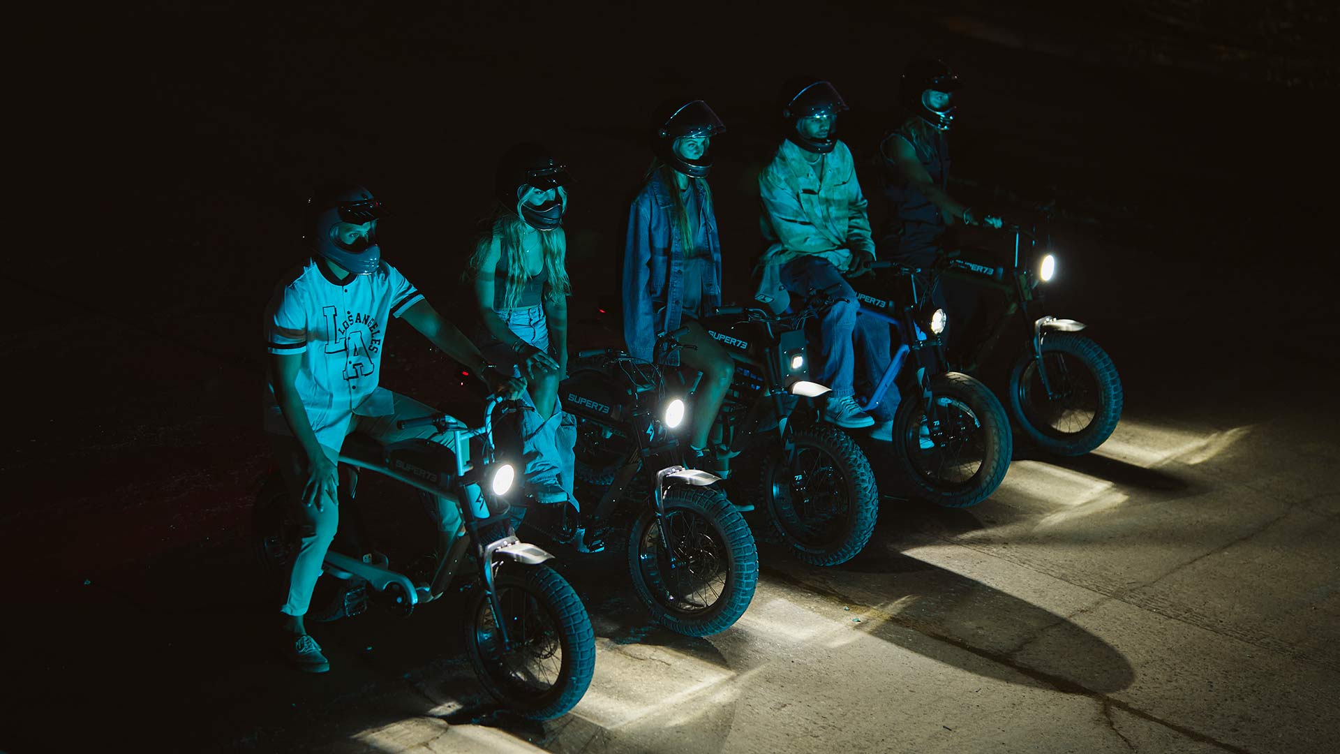 Super73 ebike riders lined up in the dark with headlamps on