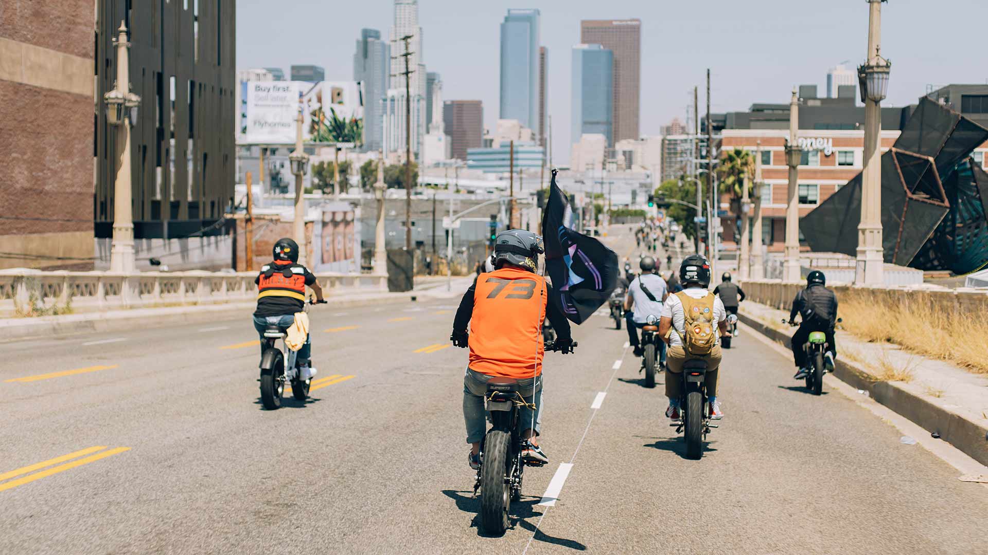 Group ride driving Super73 ebikes on urban streets