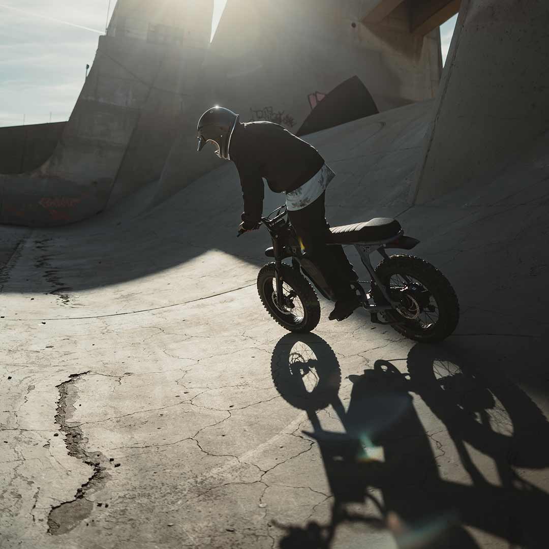 Lifestyle image of a rider riding the S Adventure down a cement slope wearing a helmet.