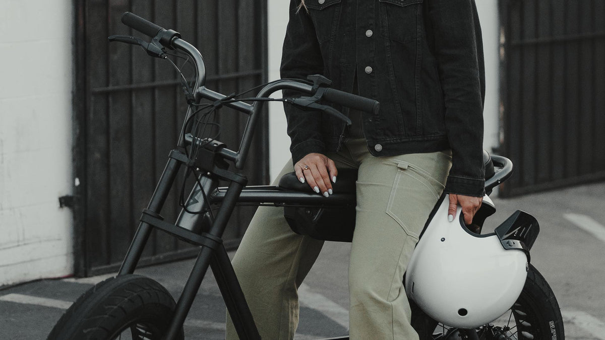 rider holding white helmet with Super73 ZX ebike